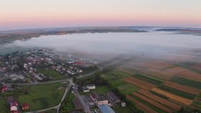 4k drone forward video (Ultra High Definition) of summer sunrise on Ternopil outskirts with asphalt road. Foggy morning view of the Ukrainian village. Beauty of countryside concept background.