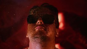 Calmness relax chill face man in gold glitter.Comical video funny person.Blowing powder.Serenity control stability positive emotion guy in sunglasses.Blow smoke spray gold dust in slow motion 1000fps