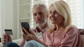 Elderly happy Caucasian married couple senior man woman retired make order purchase at online shop using phone pension credit card enjoy easy buying at ecommerce website use electronic bank services - Powered by Shutterstock - Get 15% off with code: PIKWIZARD15