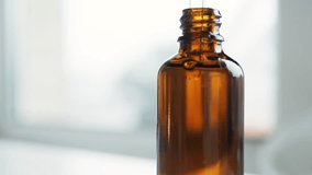 One cosmetic dark amber glass bottle with white lable on wooden table. Closeup, copyspace. Beauty blogging, salon treatment concept, minimalism brand packaging mock up. Front view. - Powered by Shutterstock - Get 15% off with code: PIKWIZARD15