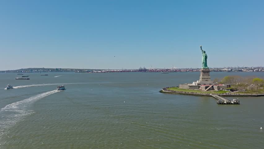 Aerial view of ferry boats on river visiting statue of liberty in New York at beautiful sunny day