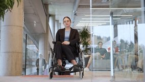 A businesswoman in a wheelchair is seen in a modern company with her colleagues discussing behind her, symbolizing a workplace that values inclusivity, diversity, and collaborative discussions - Powered by Shutterstock - Get 15% off with code: PIKWIZARD15