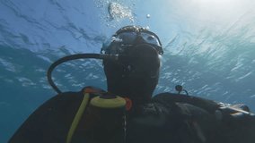 closeup Portrait of scuba diver underwater make bubbles breathing through tube with oxygen. Man in diving equipment. Sun beams permeate into deep. Marine aquatic, diving concept. Snorkeling adventure. - Powered by Shutterstock - Get 15% off with code: PIKWIZARD15