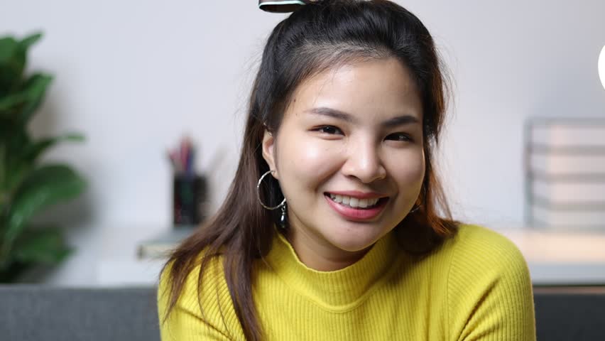 A cute and cheerful Asian girl woman is smiling and flirting.