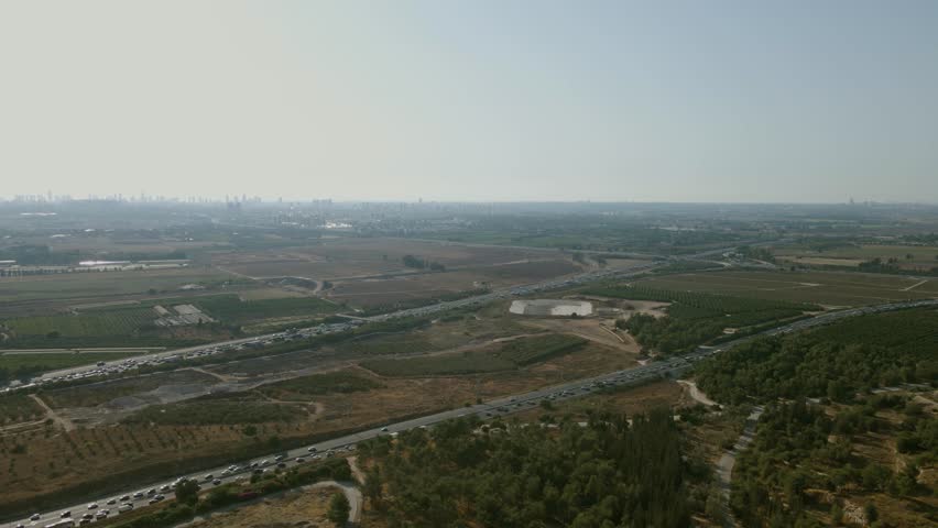 A main road in central Israel, a road that crosses agricultural fields and a natural forest, on the horizon of the towers of Tel Aviv.
Highway 6 crosses Israel
Drone shot
