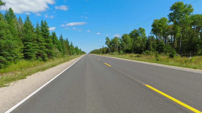 Back view Driving Plate looking backward. POV driving car view. Highway 540, straight road. Point of view Road behind with farms and pasture land: Manitoulin Island, Ontario, Canada – August 28 2023. Royalty-Free Stock Footage #1110989493