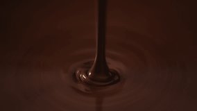 Slow motion shot pouring melted chocolate, close-up seamless dripping hot liquid chocolate flows, waves flowing molten chocolate or dark caramel sauce. Chocolate wavy drip. Confectionery cooking - Powered by Shutterstock - Get 15% off with code: PIKWIZARD15