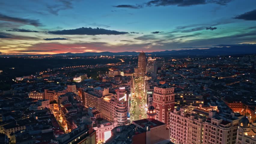 Establishing aerial view of Madrid Gran Via buildings architecture, rush hour traffic and Torre de Madrid on a beautiful sunset sky. Aerial Hyperlapse Time Lapse of Madrid city center Royalty-Free Stock Footage #1111009387