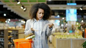 Woman shopper takes out a paper check in a grocery store in supermarket is very surprised at the high prices, rising inflation. Gets shocked looking at check after shopping. consumer standing in mall  - Powered by Shutterstock - Get 15% off with code: PIKWIZARD15
