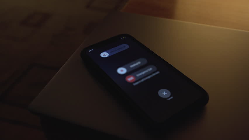 Hand using is sliding to turn off the mobile phone to reduce power consumption