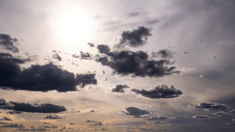 Timelapse of cumulus clouds moving in the blue sky against the sun. Cloud space background with many light and grey clouds changing shape, time lapse. Change of weather. Nature, sky clouds, copy space Arkivvideo
