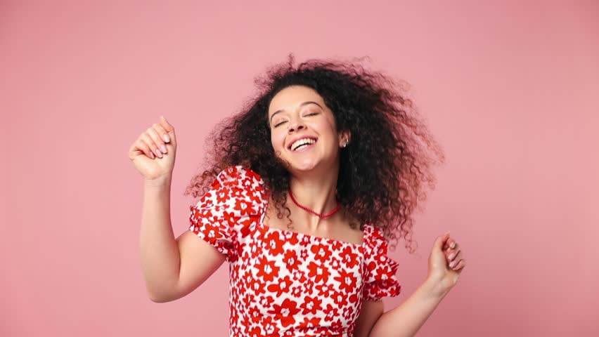 Fancy vivid happy cheerful bright young latin woman wear red casual clothes dance wave rising have fun enjoy relax celebrate play fluttering hair isolated on pastel plain light pink background studio