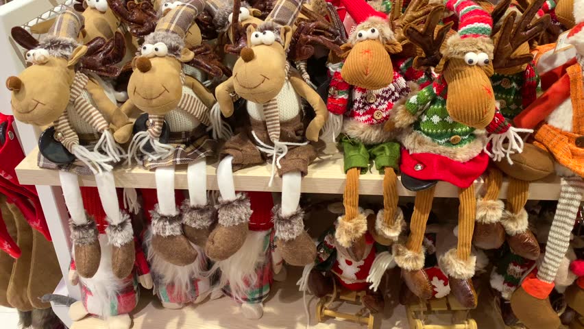 stuffed deer toys on the store shelf. Christmas trees toys, and festive decorations are on display on a store shelf. 