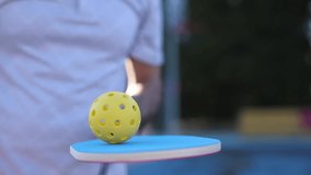 Pickleball player juggling with a ball in slow motion
