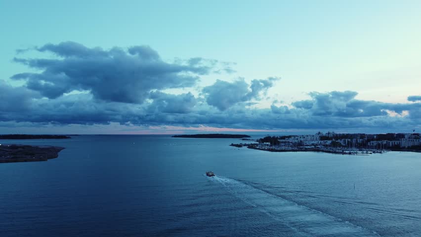 Lone ferry ship departs port of Helsinki at dawn on blue Baltic Sea