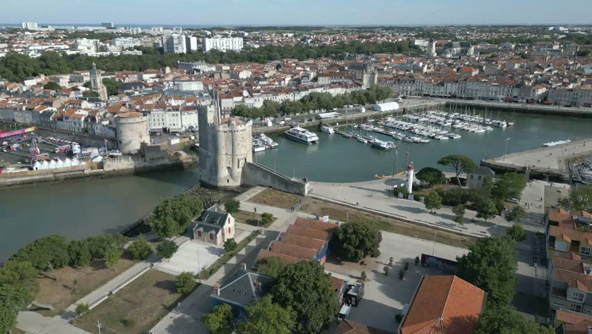 Old port of La Rochelle with Chain and Saint Nicolas towers, France. Aerial forward