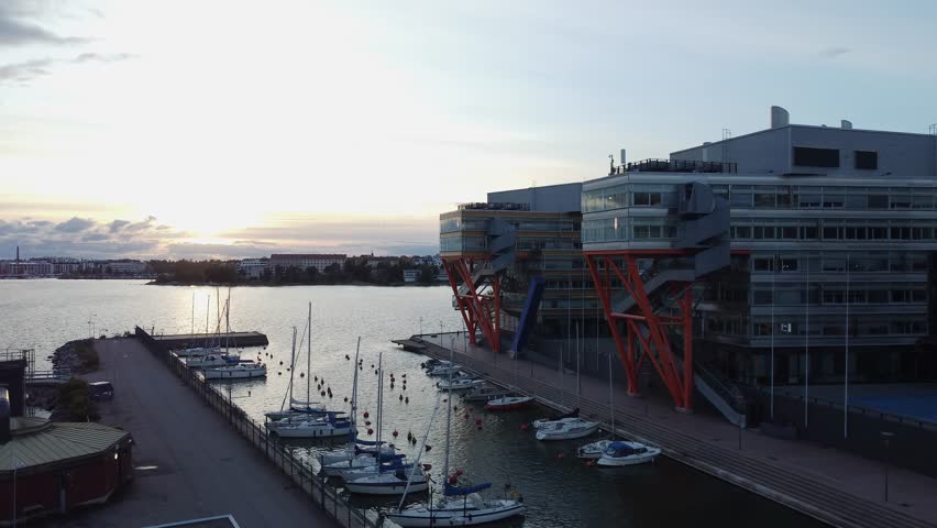 Evening aerial rises over marina and waterfront buildings in Helsinki