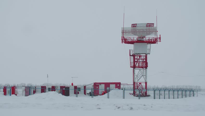 A control tower at the airport in snowfall weather while winter