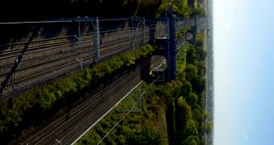 Aerial shot of a fast passenger train in the UK countryside. Speed Passenger train to London. Commuting train transportation. Aerial vertical, vertical video background.