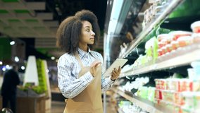 African american employee clerk working on tablet, checking condition of product in a grocery store market near shelves Black woman, manager checks the expiration date inventory in supermarket - Powered by Shutterstock - Get 15% off with code: PIKWIZARD15