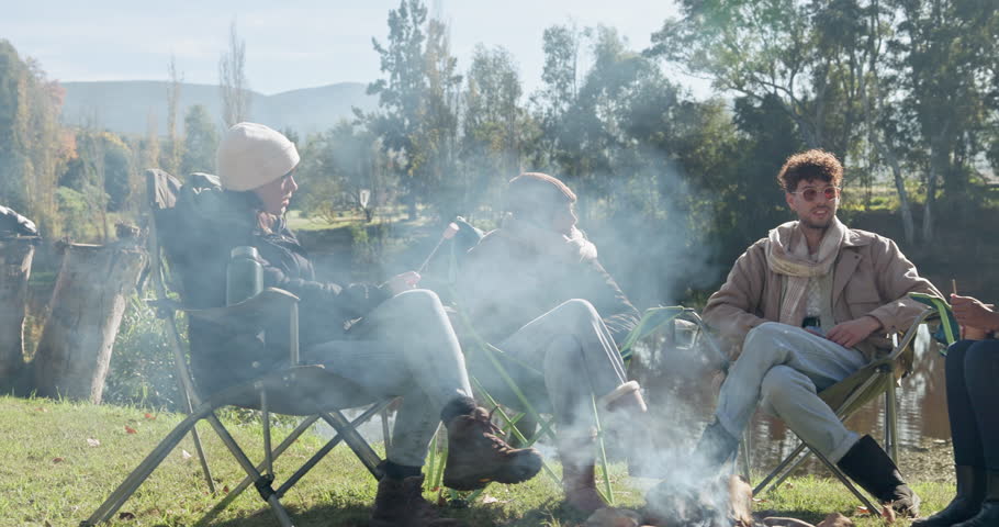 Discussion, camping or friends by campfire to relax on holiday, vacation or weekend break in nature. Travel, men or women talking, speaking or enjoying conversation while camping together on fun trip