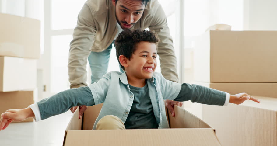 Father, kid and playing in box on moving day in lounge for freedom or bond with family in home. Happy, parent and son in house for real estate with games or celebration with investment and property. Royalty-Free Stock Footage #1111049057
