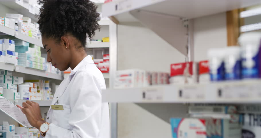 Pharmacist, woman and tablet by pharmacy shelf, medicine research and inventory management of sales or price. Professional worker or face of doctor typing on digital technology for medical store data