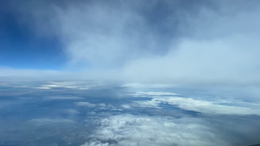 Aerial time lapse shot from an airplane flying through some clouds in a sunny day with a deep blue sky. A pilot’s perspective. Royalty-Free Stock Footage #1111050671