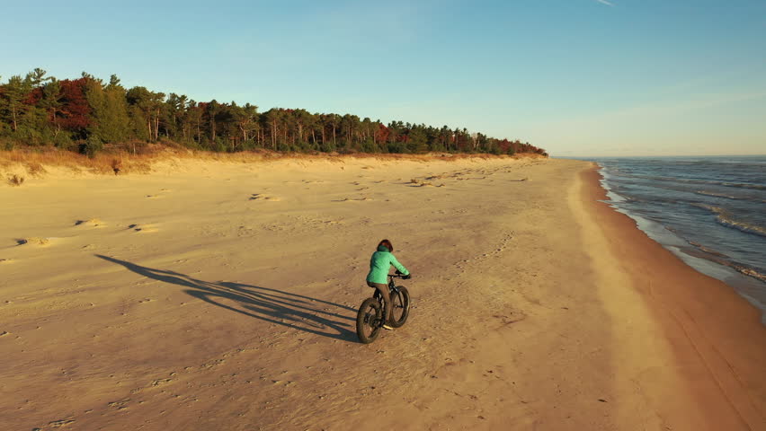 Fat Bike beach ride. Aerial drone view. Golden hour, sunrise, sunny morning. Wisconsin, USA