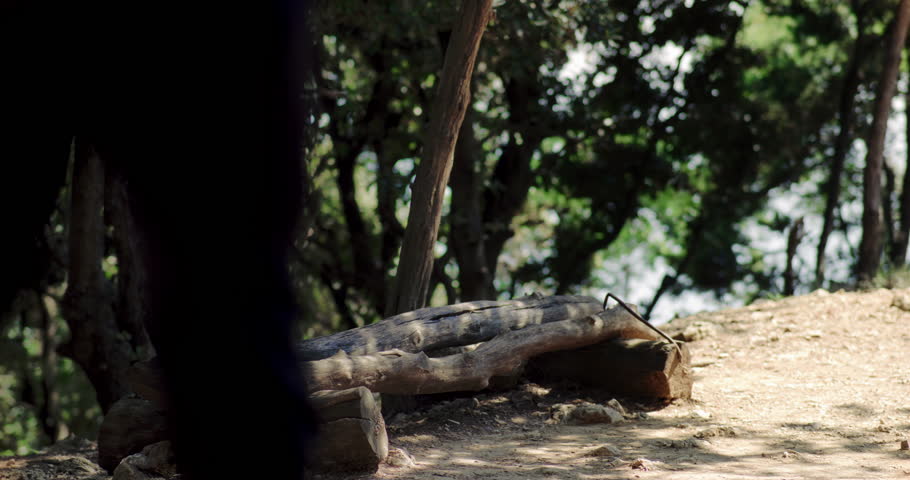 Family hikes together taking a break to drink water and relax in shade, setting down heavy packs