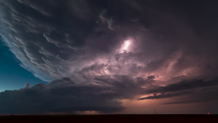 A massive supercell churns through the New Mexico landscape after dark. Stars shine as the storm spins into the night.