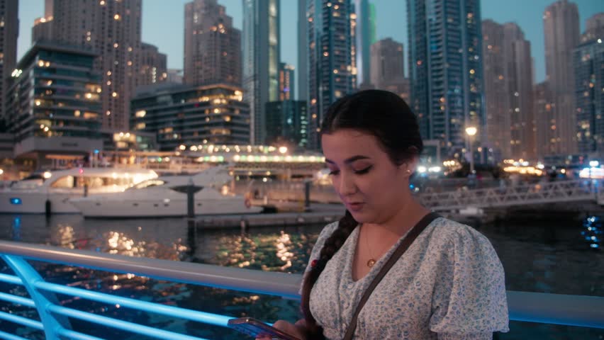Teenage girl talking on smartphone in Dubai Marina