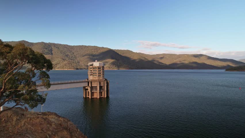 Low aerial over the water towards the intake tower at Lake Eildon, Victoria, Australia