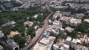Aerial video of Hyderabad's central business district. Intercity train tracks and the Khairatabad Metro railway station. Train moving to the station. Intersection of Mumbai highway and Raj bhavan.