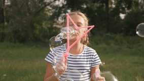 Cute little girl blowing soap bubbles. Carefree happy kid is playing in the park. Kid funni play emotions, dream in the park with soap bubbles.Concept happy family children - Powered by Shutterstock - Get 15% off with code: PIKWIZARD15
