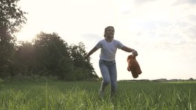 Little girl with a toy teddy bear in park. Cute girl with a teddy bear in a green field. Lonely girl with a toy teddy bear in park in green field.Teddy bear in the hands of a girl in the park - Powered by Shutterstock - Get 15% off with code: PIKWIZARD15