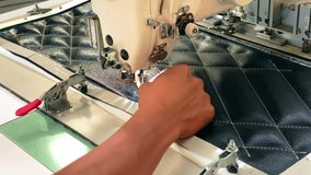 Hands threading an automatic sewing machine. Textile industry.