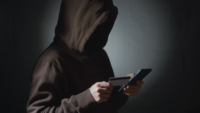 Male hacker using phone and credit card. Royalty-Free Stock Footage #1111068309