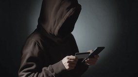 Male hacker using phone and credit card. - Powered by Shutterstock - Get 15% off with code: PIKWIZARD15