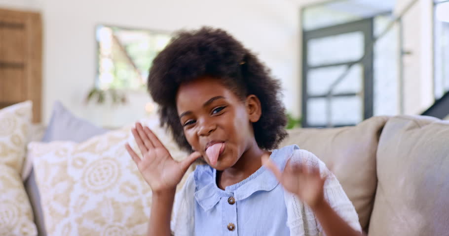 Child, funny face and happy in sofa, tongue out and playful in living room, home and alone. Crazy, comic and facial expression with portrait, silly and goofy for childhood games, personality and girl