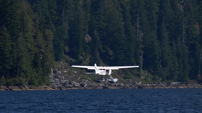 Seaplane Landing Over Blue Water Lake In British Columbia, Canada. Wide Shot