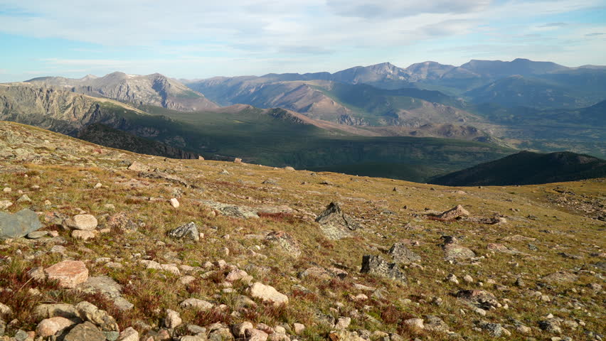 Cinematic Rocky Mountain National Park above treeline Colorado Denver Boulder Estes Park 14er Longs Peak looking out to Indian Peaks sunny late summer dramatic landscape pan slowly left