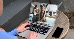Animation of like icons floating over rear view of woman having video call on laptop at a cafe. Social media networking and business technology concept