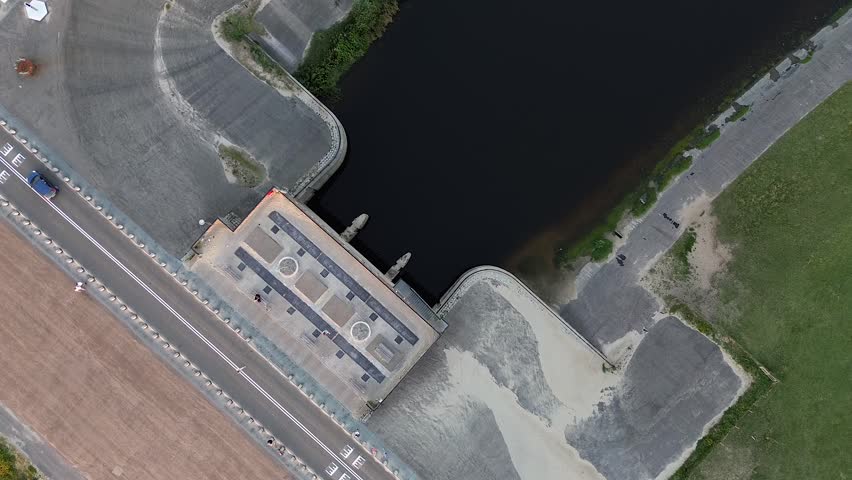 Beautiful view from above to the dam between the river and the North Sea. View from a quadrocopter to a car, road, a beach and a clearing with green grass. View from the drone river.