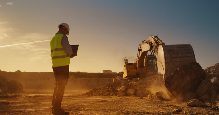Caucasian Male Inspector Using Laptop Computer On Construction Site Of New Real Estate Project. Man Observing Industrial Machinery At Work, Laying Foundation For Apartment Building. Sunny Evening Royalty-Free Stock Footage #1111090499