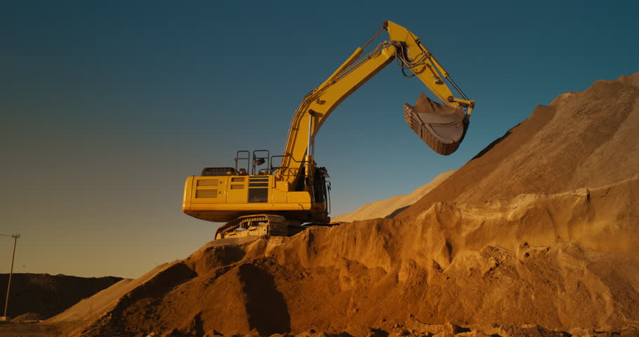 Construction Site On A Hot Sunny Day: Industrial Excavator Digging Sand To Lay Foundation for Building New Apartment Block. Workers Operating Heavy Machinery To Complete A Real Estate Project.