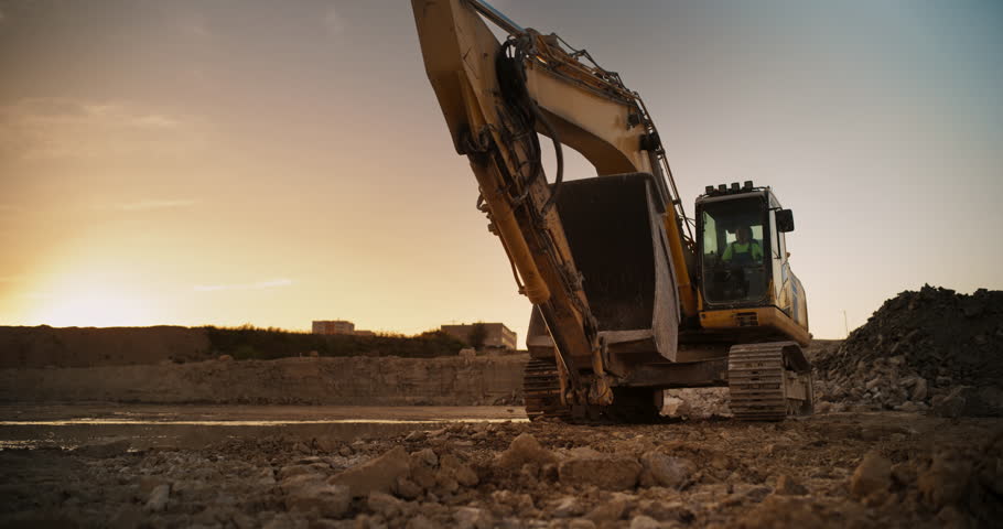 Construction Site On Sunny Evening: Industrial Excavator Driving To Complete Work Tasks Related To Building New Real Estate Project. Man Operating Heavy Machinery To Build New Apartment Complex. Royalty-Free Stock Footage #1111090573