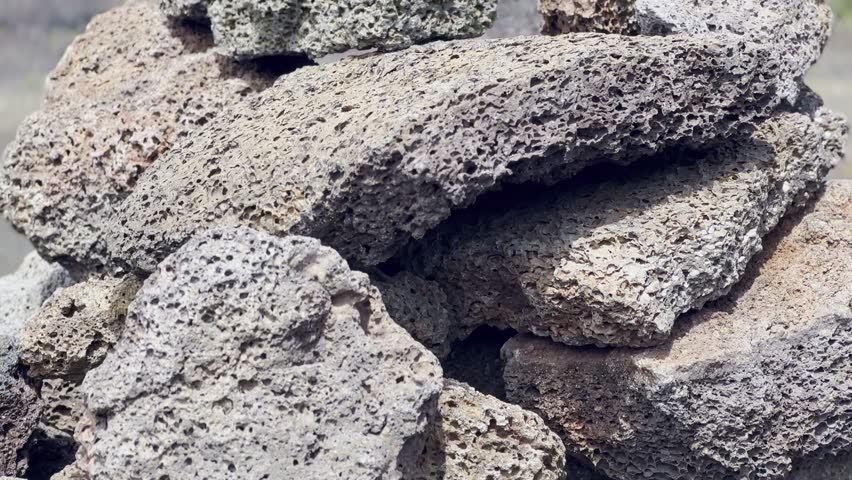 Cinematic booming up shot over a trail cairn to reveal the steep slopes of the Kilauea Iki crater in Hawai