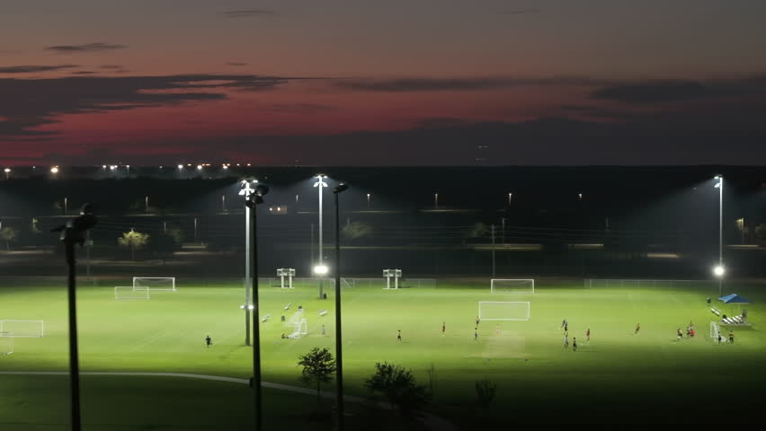 Illumination turned off on public sports arena in North Port, Florida with people playing soccer game on grass football stadium at night. Blackout concept Royalty-Free Stock Footage #1111095033