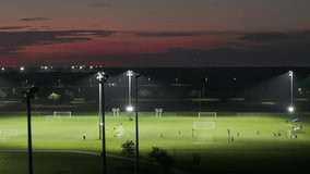 Illumination turned off on public sports arena in North Port, Florida with people playing soccer game on grass football stadium at night. Blackout concept - Powered by Shutterstock - Get 15% off with code: PIKWIZARD15